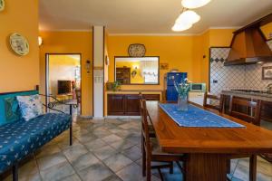 a kitchen and dining room with a table and a couch at Villa Maria Antonietta in Sassari