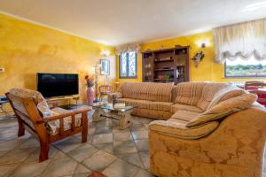 a living room with a couch and a tv at Villa Maria Antonietta in Sassari