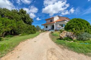 a dirt road leading to a white house at Villa Maria Antonietta in Sassari