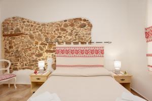 a bedroom with a bed and two tables with lamps at Appartamento Irgoli - Sardegna in Irgoli
