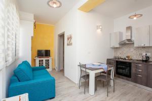 a kitchen and living room with a blue couch and a table at Appartamento Irgoli - Sardegna in Irgoli