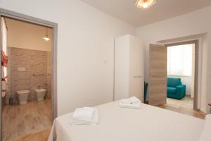 a white bedroom with a bed and a blue couch at Appartamento Irgoli - Sardegna in Irgoli