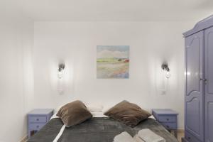 a bedroom with a bed and a painting on the wall at Casa Paula - 25 in Arinaga +18 photos