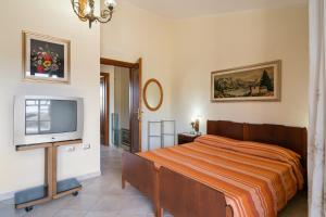 a bedroom with a bed and a flat screen tv at Villamara in Olìa Speciosa