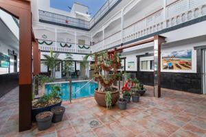 a large building with a pool and potted plants at Casa Paula - 25 in Arinaga