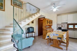 a kitchen and a living room with a staircase at Villamara in Olìa Speciosa +17 photos