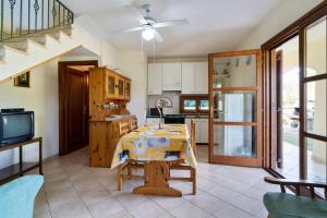 a living room with a table and a kitchen at Villamara in Olìa Speciosa