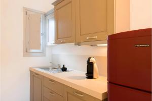 a kitchen with a sink and a red refrigerator at Echinousa Kimolos katoikia no5 in Kimolos