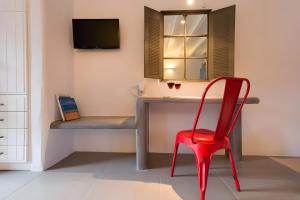 a red chair in front of a desk with a television at Echinousa Kimolos katoikia no5 in Kimolos
