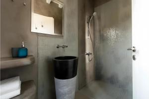 a bathroom with a shower with a trash can at Echinousa Kimolos katoikia no5 in Kimolos +14 photos