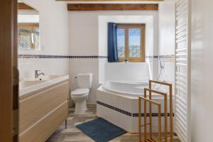 a bathroom with a tub and a toilet and a sink at Le Ranch Des Ours in Champsac +27 photos