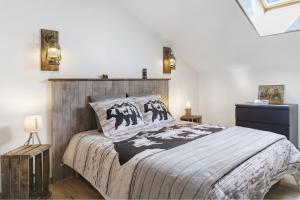 a bedroom with a large bed with a wooden headboard at Le Ranch Des Ours in Champsac