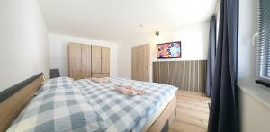 a bedroom with a bed with a blue and white checkered blanket at Konis Ferienwohnung - barrierearm in Rangersdorf