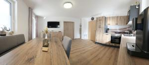 a living room with a wooden table and a kitchen at Konis Ferienwohnung - barrierearm in Rangersdorf