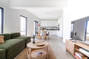 a living room with a green couch and a table at Ptm Arade View Penthouse T3 Duplex in Portimão