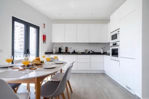 a white kitchen with a table and chairs at Ptm Arade View Penthouse T3 Duplex in Portimão