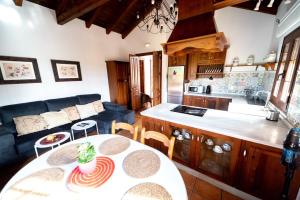 a kitchen and living room with a table and a couch at La Jacaranda in Hornachuelos