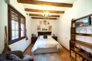 a bedroom with a bed and a chandelier at La Jacaranda in Hornachuelos +25 photos