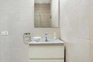a white bathroom with a sink and a mirror at Apartamento Guzmán A in Barbate +12 photos