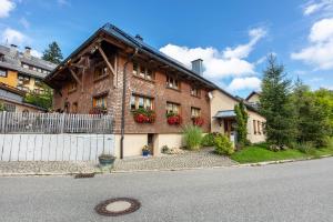 a brick house with flowers on the side of the street at Connerhof Todtnauberg in Todtnau