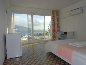 a bedroom with a bed and a large window at çiftlik tepesi pansiyon in Kumluca
