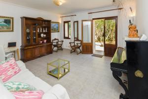 a living room with a white couch and a piano at Villa moli de ca n'orell in Santanyi