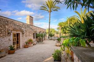 a courtyard with palm trees and a building at Villa moli de ca n'orell in Santanyi