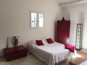 a white bedroom with a bed and a window at Ferme du Luberon in Mane
