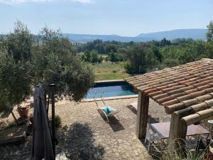a backyard with a pool and a wooden roof at Ferme du Luberon in Mane