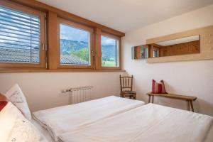 a bedroom with a bed and two windows at Försterhaus Wohnung Dachgeschoss in Egg