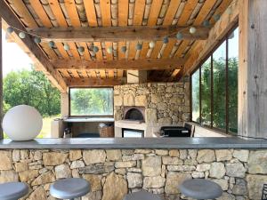 an outdoor bar with stools in front of a stone fireplace at Ferme du Luberon in Mane