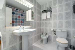 a white bathroom with a toilet and a sink at Casa García in L'Aldea +18 photos