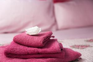 a pile of pink towels with a toothbrush on top at Su Nidu Nou in Dorgali