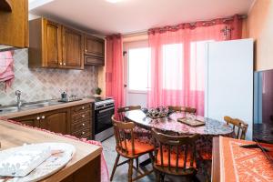 a kitchen with a table and chairs and a kitchen with a refrigerator at Su Nidu Nou in Dorgali