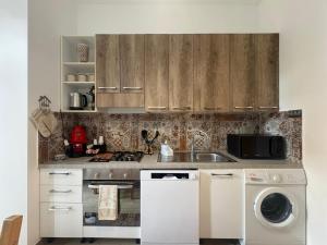 a kitchen with wooden cabinets and a sink and a dishwasher at Casa Concordia in Agrigento