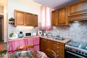 a kitchen with wooden cabinets and a sink and a microwave at Su Nidu Nou in Dorgali +16 photos
