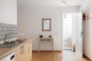 a kitchen with a sink and a mirror on the wall at Casa Rosi in Tinajo +13 photos