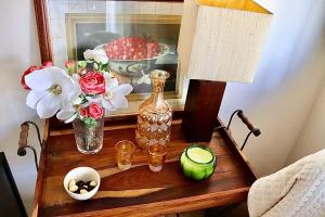 a table with a vase and flowers and a picture at A Casa dos Raminhos in Vila de Frades