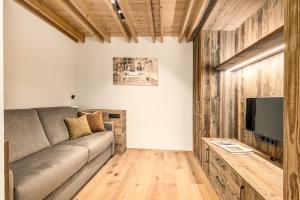 a living room with a couch and a flat screen tv at Apartments Perfila Morgenrot in Valdaora