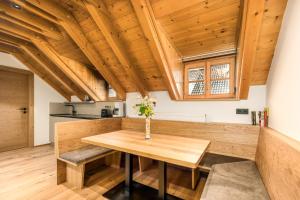 a kitchen with a wooden table in a room at Apartments Perfila Morgenrot in Valdaora