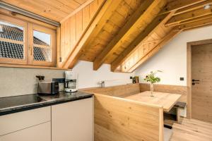 a kitchen with wooden cabinets and a wooden counter top at Apartments Perfila Morgenrot in Valdaora +6 photos