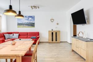 a living room with a red couch and a wooden table at Ferienwohnung Geroldsee in Garmisch-Partenkirchen