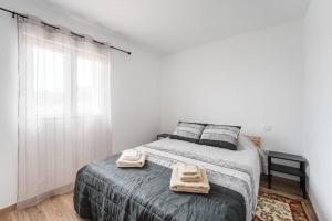 a bedroom with a bed with two towels on it at Moradia Aura Santi in Esposende +18 photos