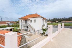a white house with a staircase and a balcony at Moradia Aura Santi in Esposende