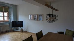 a living room with a table and a television at Appartment am Markt in Weimar