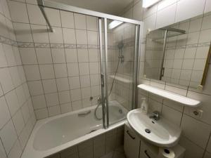 a bathroom with a sink and a shower and a tub at Appartment am Markt in Weimar +2 photos