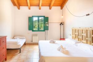 a bedroom with three beds and a window at Mas Tortós in Palafolls +37 photos