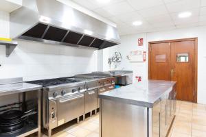 a kitchen with stainless steel appliances and a stove at Mas Tortós in Palafolls