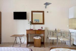 a living room with a table and a tv on the wall at Vardia studio A in Mikros Gialos