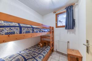 a bedroom with two bunk beds and a dog laying on the floor at Chalet de l'Ardoisière in Saint-Colomban-des-Villards